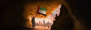 EMARATI MAN EXITTING FROM UAE MAP SHAPED MOUNTAIN EXIT HOLDING UAE FLAG AND THE VIEW OF DUBAI CITY